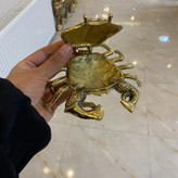 جاسیگاری طرح خرچنگ برنجی طلایی لوکس با درب لولایی بازشونده، جزییات ظریف چنگالها و بدنه، محفظه خاکستر عمیق و صقلکاری زرین متالوکس بر روی میز