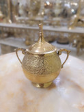 قندان تمام برنجی طلایی دارای درب و دو دسته با حکاکیهای برجسته طرح پرنده و گل روی پسزمینه محو فروشگاه متالوکس