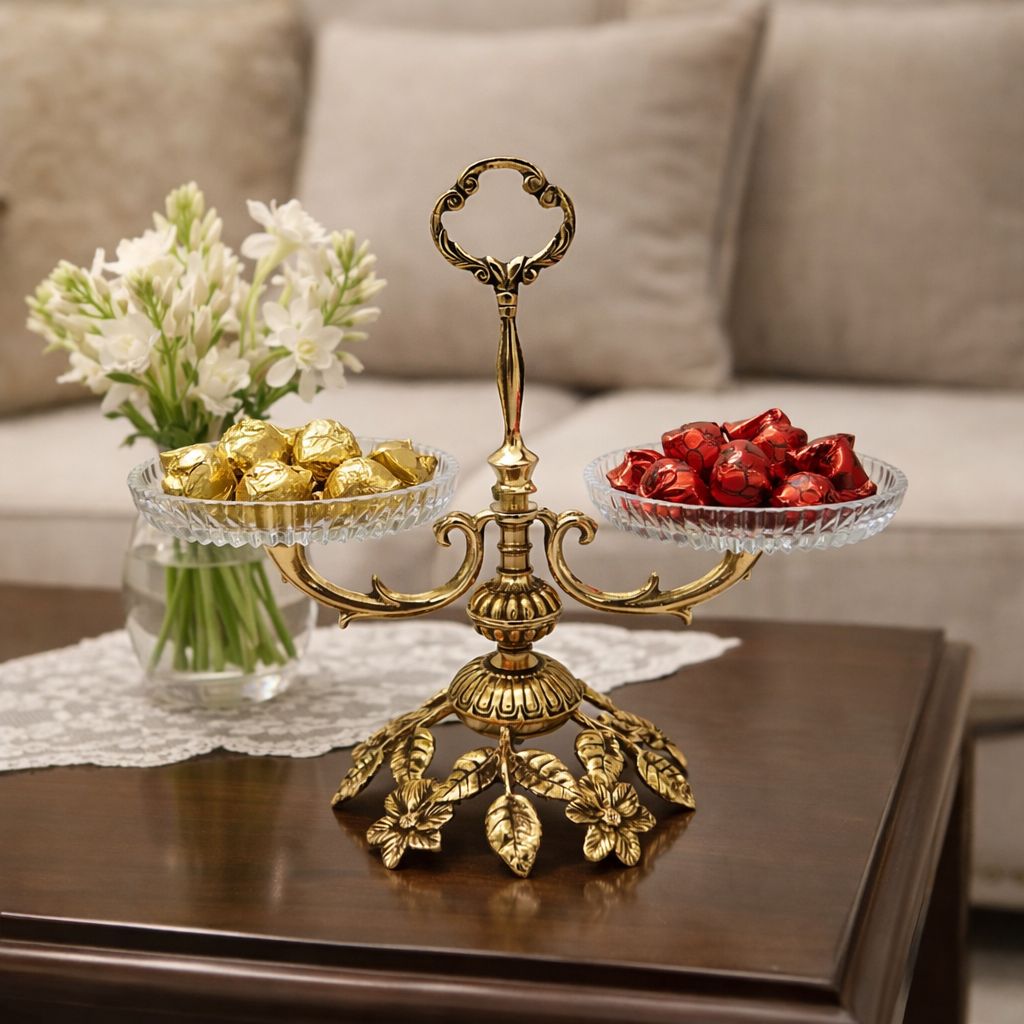 اردوخوری دو طبقه مدل کارن با پایه گل‌دار برنجی، دو ظرف کریستالی لبه‌تراش و دسته کلاسیک برنجی در مرکز روی میز چوبی